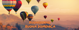 Immagine di una mongolfiera colorata che vola in alto nel cielo, con la scritta 'Buongiorno e Buona Domenica'. Un augurio di leggerezza e nuove prospettive per la giornata
