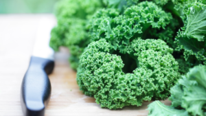 Foglie di cavolo riccio, mostrando la loro densità nutrizionale con vitamine A, C e K, e minerali come calcio e potassio, perfette per migliorare la salute generale.