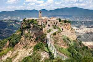 Civita di Bagnoregio, situata nel Lazio, è un borgo affascinante che sembra sospeso nel tempo. Con il suo ponte pedonale che lo collega al mondo esterno e le stradine pittoresche, offre un'atmosfera unica e tranquilla. Perfetta per una fuga romantica