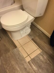 Adesivi per pavimenti vinilici applicati su un pavimento di bagno, mostrando un design moderno e colorato."