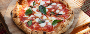 La pizza Margherita è il simbolo per eccellenza della cucina napoletana e italiana. Con una base soffice e croccante, condita con salsa di pomodoro, mozzarella filante e foglie di basilico fresco, rappresenta l'equilibrio perfetto tra semplicità e gusto. Ogni morso è un viaggio nei sapori autentici dell’Italia, con ingredienti freschi e genuini che celebrano la tradizione.